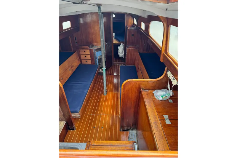 Slide: The Image of Interior of 1960 Alden Challenger 38 sailboat with wooden furnishings and blue cushions. - 11