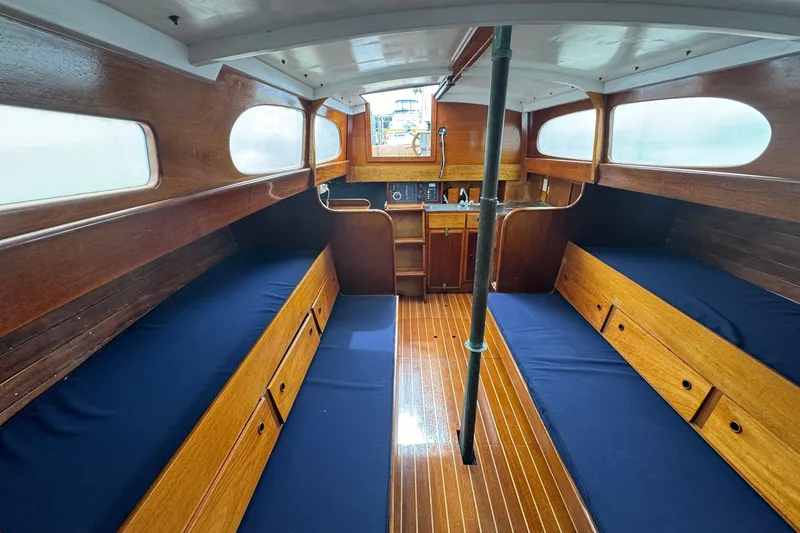 Slide: The Image of Interior of a 1960 Alden Challenger 38 sailboat with wooden finish and blue seating. - 12