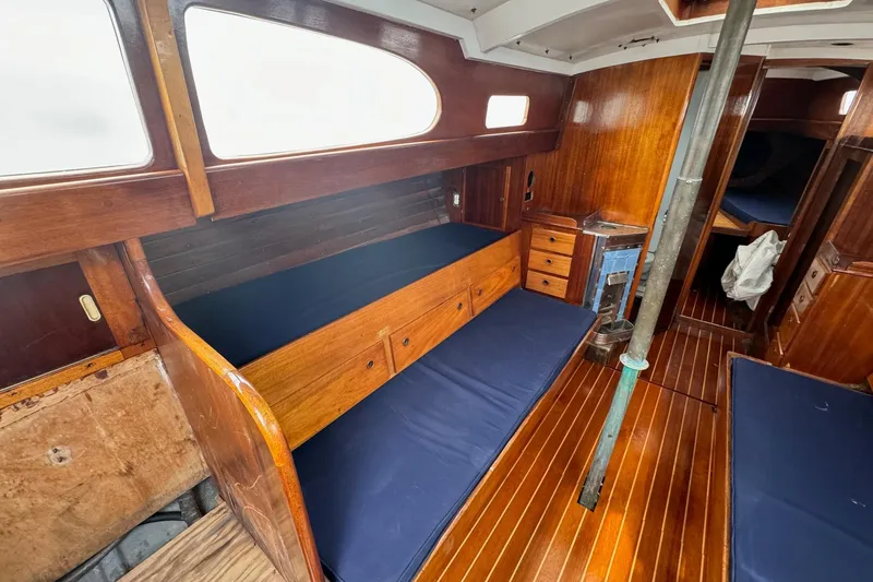 Slide: The Image of Interior of 1960 Alden Challenger 38 sailboat with wooden furnishings and blue cushions. - 13