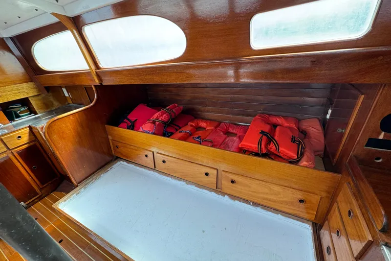 Slide: The Image of Interior of 1960 Alden Challenger 38 sailboat with wooden cabinetry and life jackets. - 14