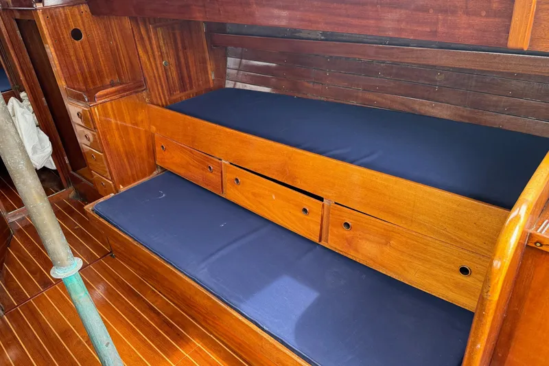 Slide: The Image of Interior of 1960 Alden Challenger 38 sailboat with wooden cabinetry and blue cushions. - 15