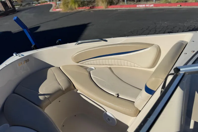 Slide: The Image of 2004 Glastron GX 235 boat interior with beige seating and blue accents. - 10