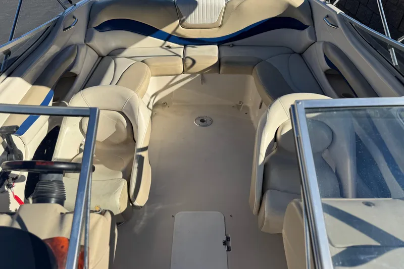 Slide: The Image of 2004 Glastron GX 235 boat interior with beige seating and steering wheel. - 11