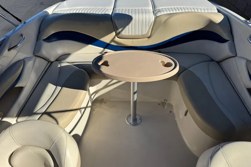 Slide: The Image of 2004 Glastron GX 235 boat interior with beige seating and a small round table. - 12