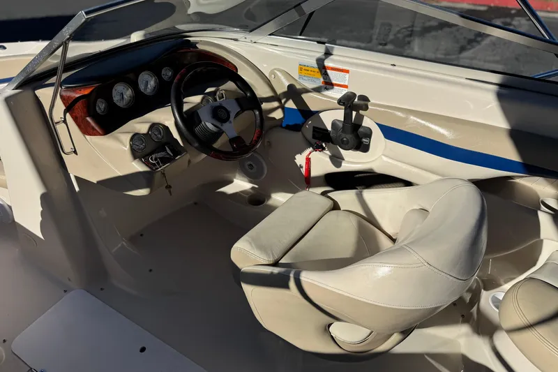 Slide: The Image of 2004 Glastron GX 235 boat interior with steering wheel and dashboard controls. - 20