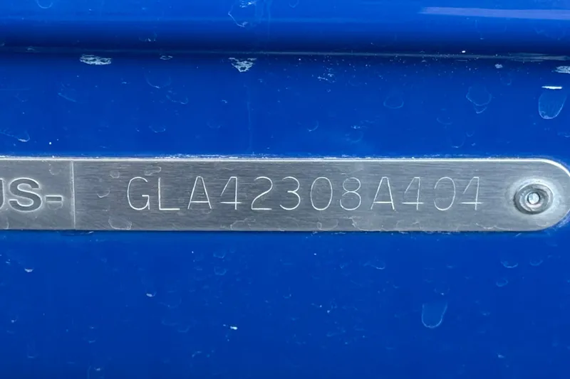 Slide: The Image of 2004 Glastron GX 235 boat hull identification number on blue surface. - 27