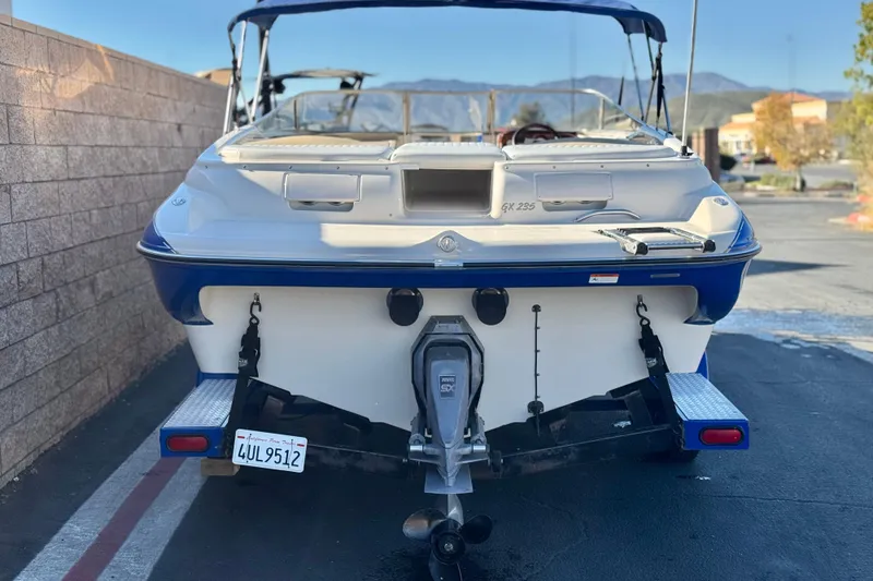 Slide: The Image of 2004 Glastron GX 235 boat, rear view, parked outdoors with visible license plate. - 4