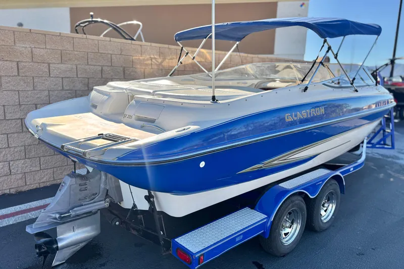 Slide: The Image of 2004 Glastron GX 235 boat with blue and white design on a trailer. - 5
