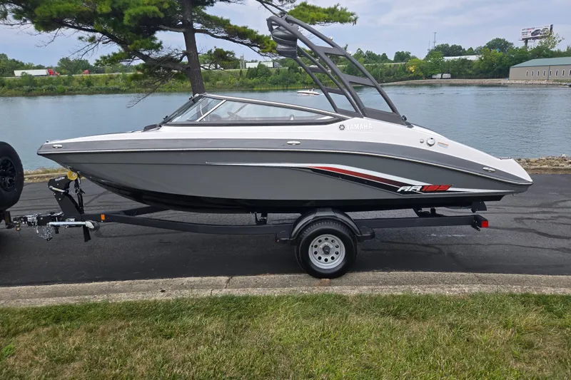 Slide: The Image of 2019 Yamaha Boats AR195 on trailer by a lakeside road. - 10