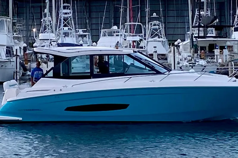 The Image of 2025 Regal 36 XO boat docked in a marina with other vessels. - 0