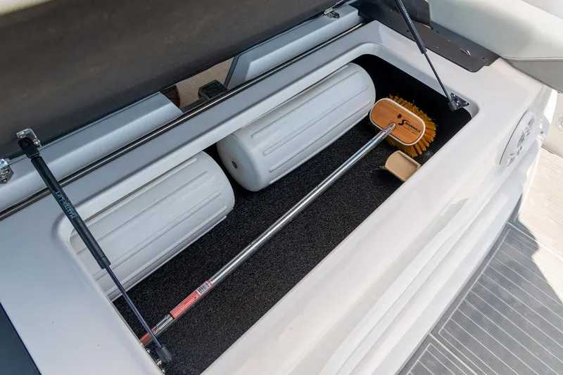 Slide: The Image of Manufacturer Provided Image: Storage compartment in 2025 Regal 36 XO boat with fenders and cleaning brush. - 10