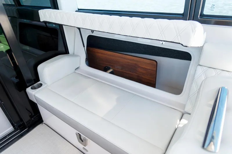 Slide: The Image of Manufacturer Provided Image: 2025 Regal 36 XO boat interior seating with white upholstery and storage compartment. - 11