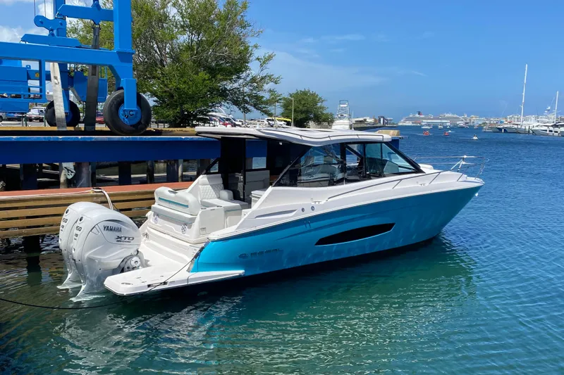 Slide: The Image of 2025 Regal 36 XO boat docked with Yamaha engines, clear blue sky. - 2