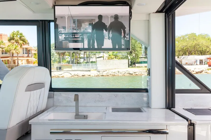 Slide: The Image of Manufacturer Provided Image: Interior of 2025 Regal 36 XO yacht with TV and waterfront view. - 8
