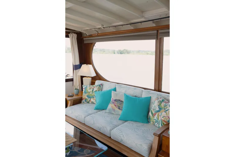 Slide: The Image of Cozy boat interior with tropical-themed cushions and large window view. - 10