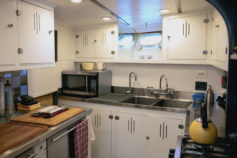 Slide: The Image of Vintage 1954 Grebe Sedan kitchen with white cabinets, stainless steel sink, and modern appliances. - 12