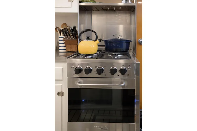 Slide: The Image of Modern kitchen stove with yellow kettle and blue pot on burners. - 13
