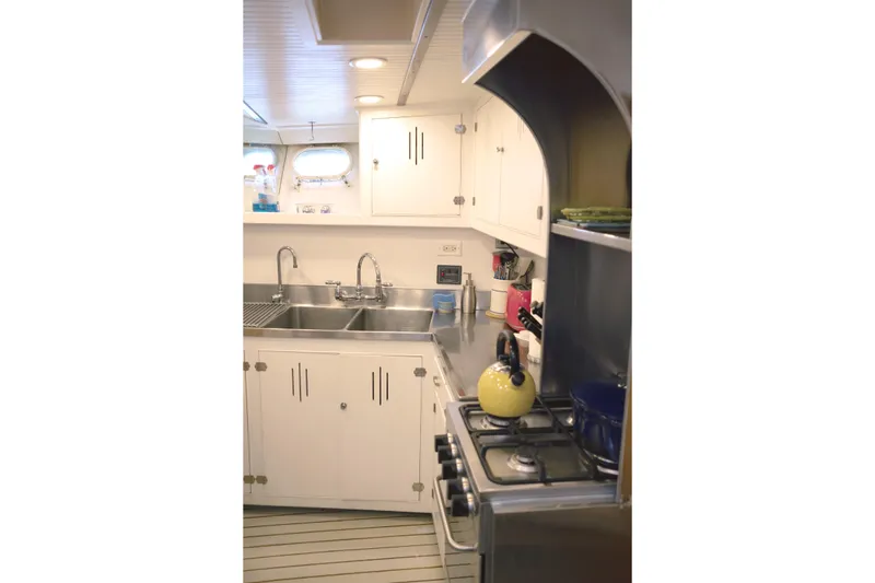 Slide: The Image of Compact kitchen with stainless steel sink, stove, and white cabinets in a 1954 Grebe Sedan. - 14
