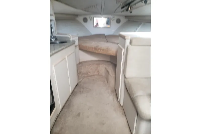 Slide: The Image of Interior of 1995 Blackfin 31 Combi boat, featuring cozy seating and compact kitchen area. - 19