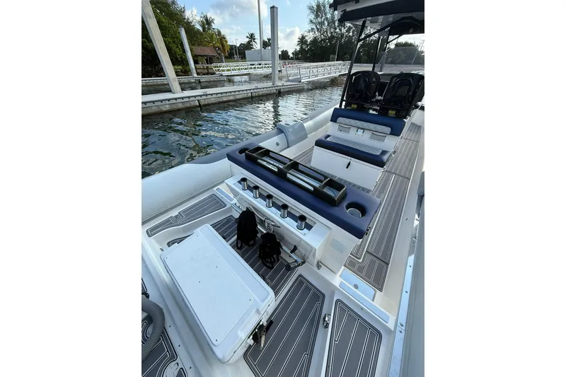 Slide: The Image of 2018 RIB CVL Colt 35 boat interior with seating and storage, docked by the water. - 20