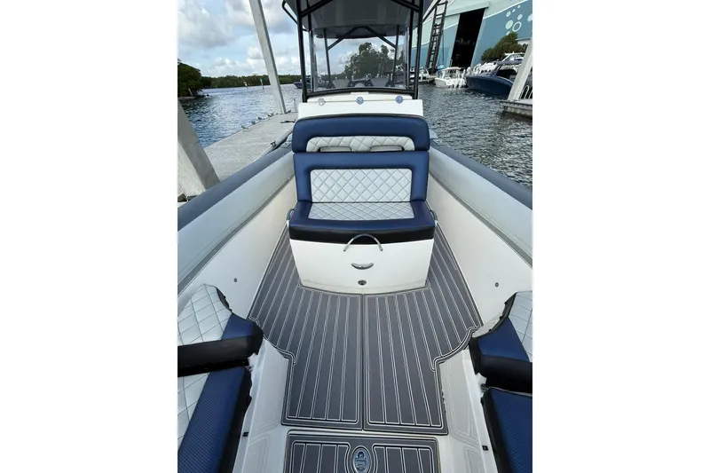 Slide: The Image of 2018 RIB CVL Colt 35 boat interior with blue and white seating, docked by the water. - 48