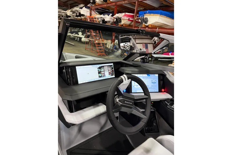 Slide: The Image of 2026 MasterCraft XStar 25 dashboard with advanced digital displays and steering wheel in a showroom. - 6