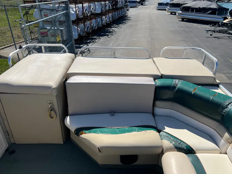 Slide: The Image of 1998 Fisher Freedom 200 DLX pontoon boat with beige and green seating, docked in a marina. - 15