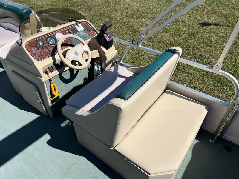 Slide: The Image of 1998 Fisher Freedom 200 DLX boat interior with beige seating and control panel. - 18