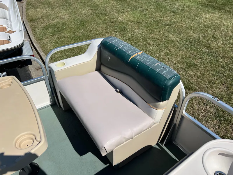 Slide: The Image of 1998 Fisher Freedom 200 DLX boat seat with cup holder, on green grass. - 23