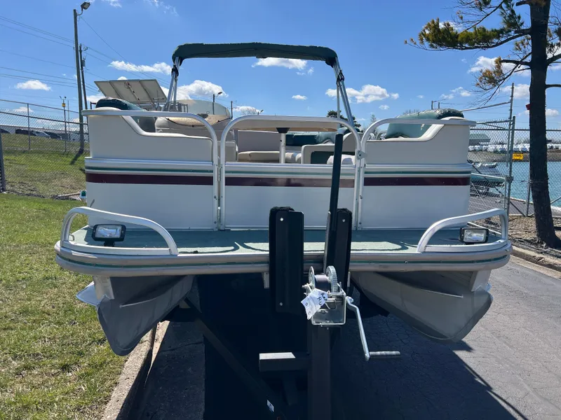Slide: The Image of 1998 Fisher Freedom 200 DLX pontoon boat on trailer, parked outdoors. - 3