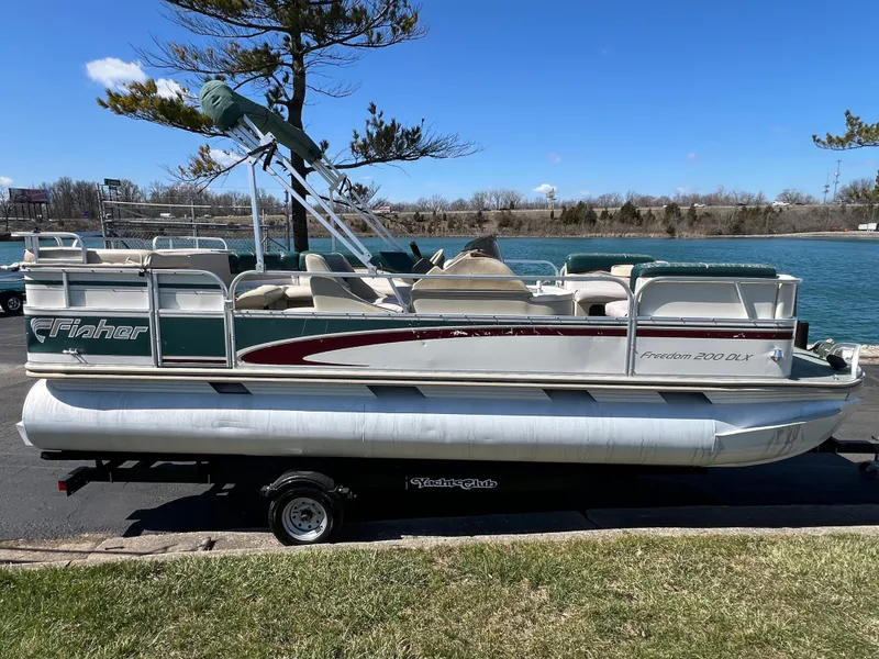 Slide: The Image of 1998 Fisher Freedom 200 DLX pontoon boat on trailer by a lake. - 4