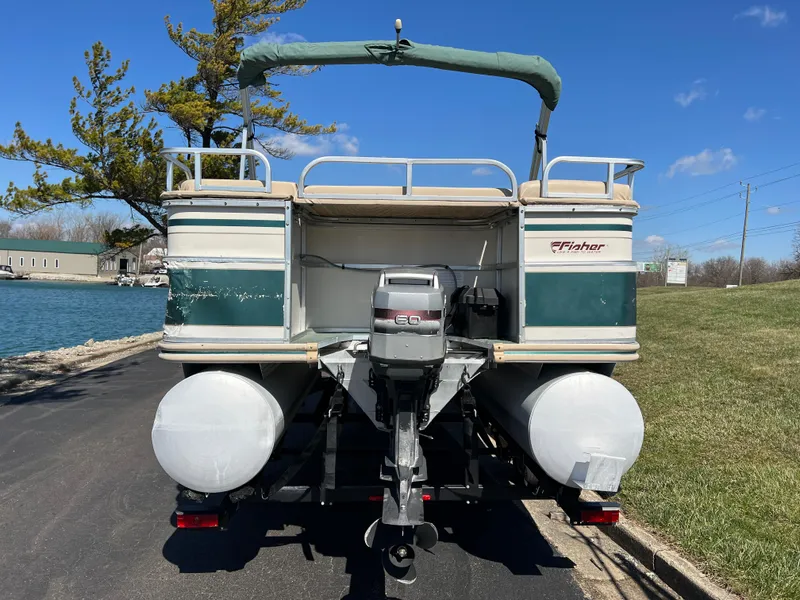 Slide: The Image of 1998 Fisher Freedom 200 DLX pontoon boat on trailer by a lake. - 6
