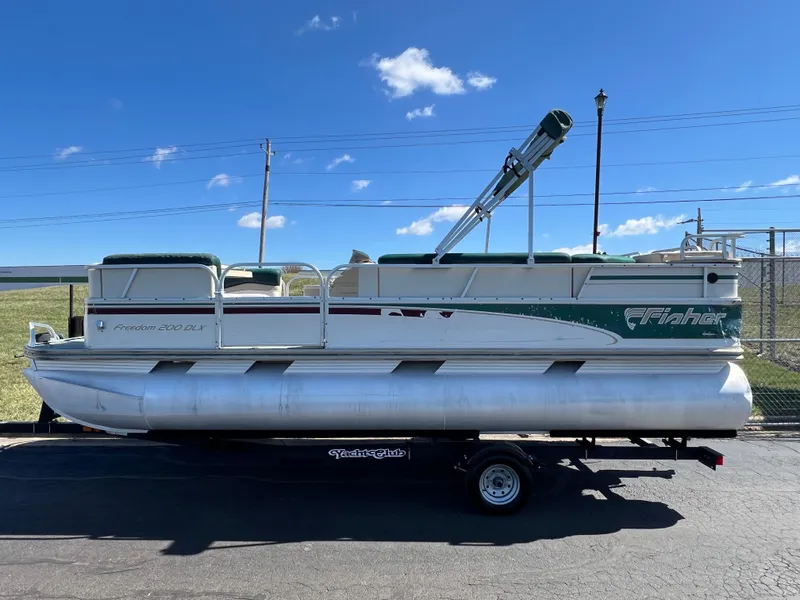 Slide: The Image of 1998 Fisher Freedom 200 DLX pontoon boat on trailer under clear blue sky. - 8