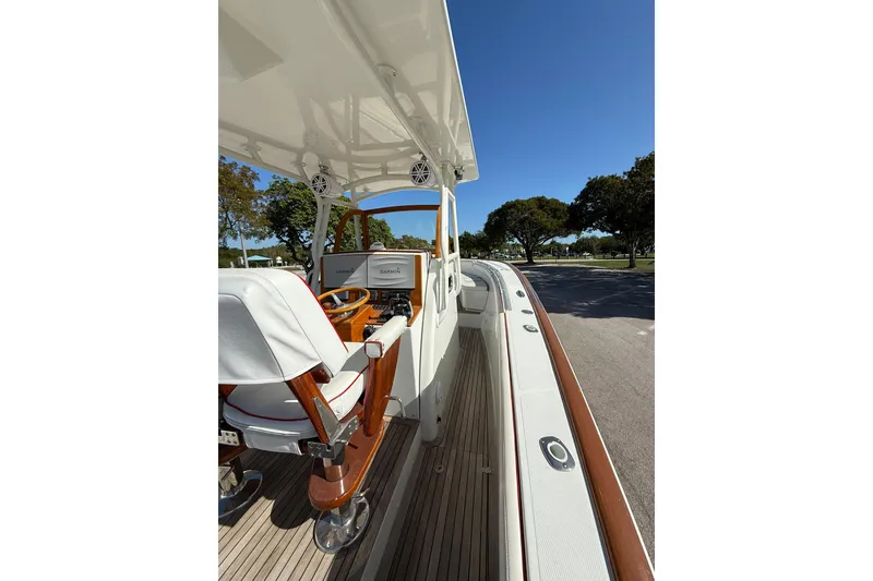 Slide: The Image of 2006 Buddy Davis 34 Center Console boat interior with helm and seating, under clear blue sky. - 23