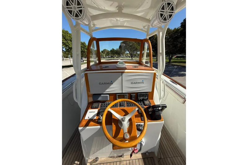 Slide: The Image of 2006 Buddy Davis 34 Center Console helm with Garmin navigation system and wooden steering wheel. - 25