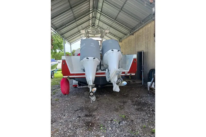 Slide: The Image of 2006 Buddy Davis 34 Center Console boat on trailer, red hull, Yamaha engines, parked outdoors. - 3