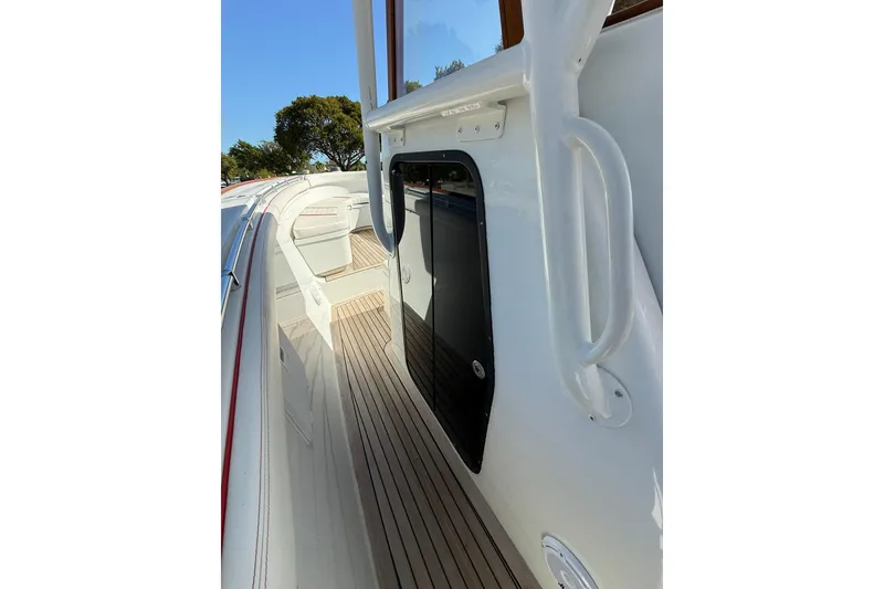 Slide: The Image of 2006 Buddy Davis 34 Center Console boat deck with sleek white design and wooden flooring. - 30