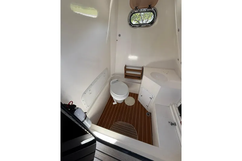 Slide: The Image of Interior of 2006 Buddy Davis 34 Center Console boat, featuring a compact marine toilet. - 32