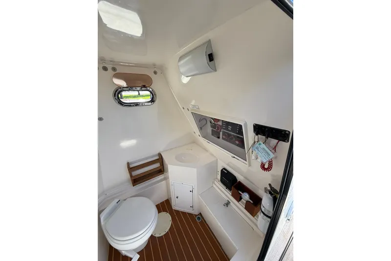 Slide: The Image of Interior of 2006 Buddy Davis 34 Center Console boat, featuring a compact bathroom setup. - 33