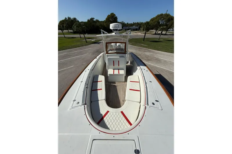 Slide: The Image of 2006 Buddy Davis 34 Center Console boat with white seating and red accents, parked outdoors. - 47