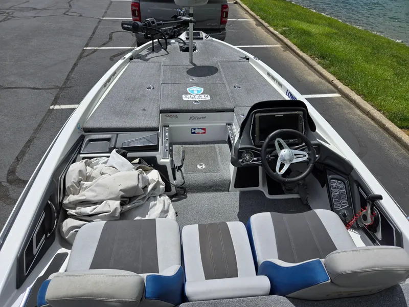 Slide: The Image of 2015 Skeeter FX 20 boat interior with steering wheel and seating, parked near water. - 11