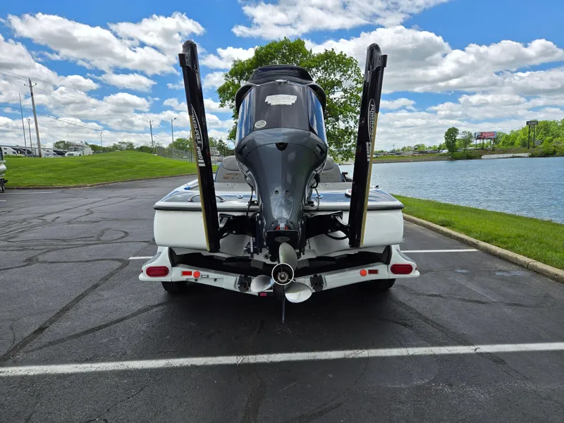 Slide: The Image of 2015 Skeeter FX 20 boat parked near a lake under a cloudy sky. - 2