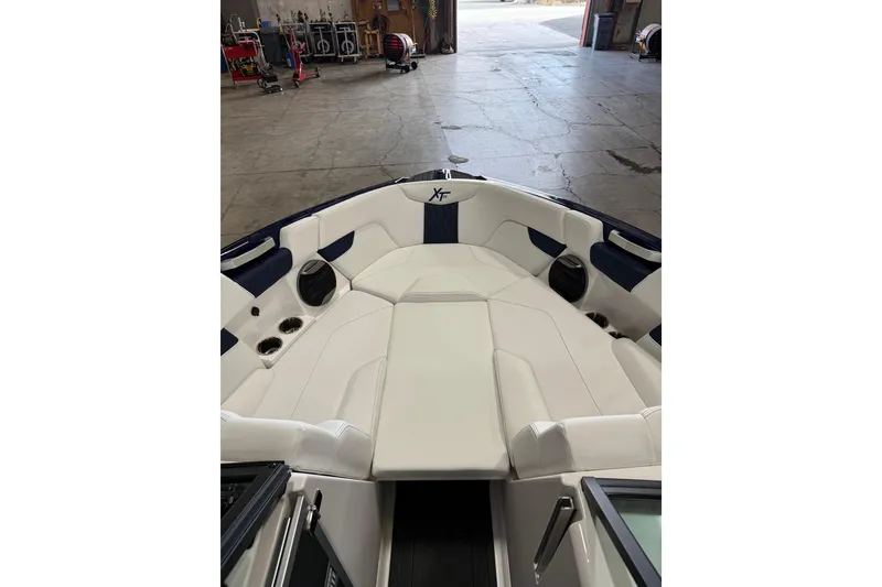 Slide: The Image of 2026 MasterCraft XT23 boat interior with white seating and cup holders in a garage setting. - 3
