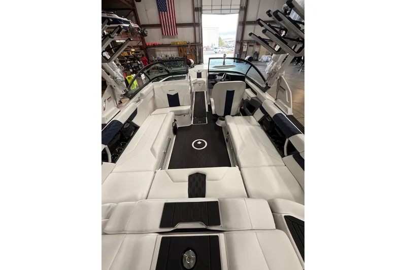 Slide: The Image of 2026 MasterCraft XT23 boat interior with sleek white seating and modern design in a showroom. - 4