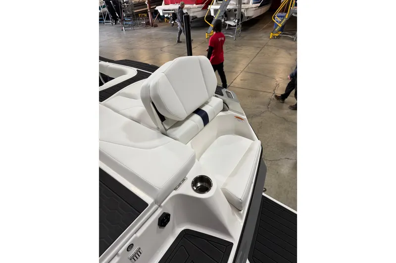 Slide: The Image of 2026 MasterCraft XT23 boat interior with white seating and cup holder in a showroom. - 8