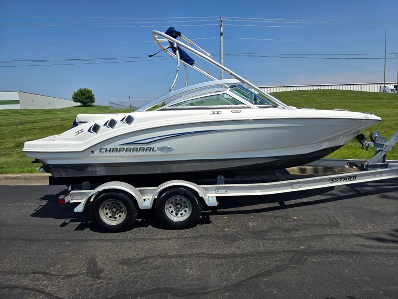 Slide: The Image of 2011 Chaparral 196 SSi boat on trailer, parked on asphalt, under clear blue sky. - 4