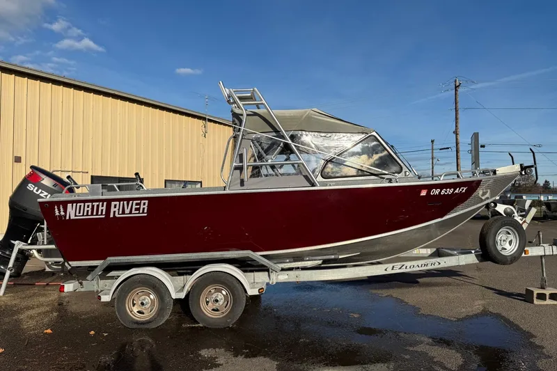 Slide: The Image of 2016 North River Seahawk boat on trailer, red exterior, parked outdoors. - 1