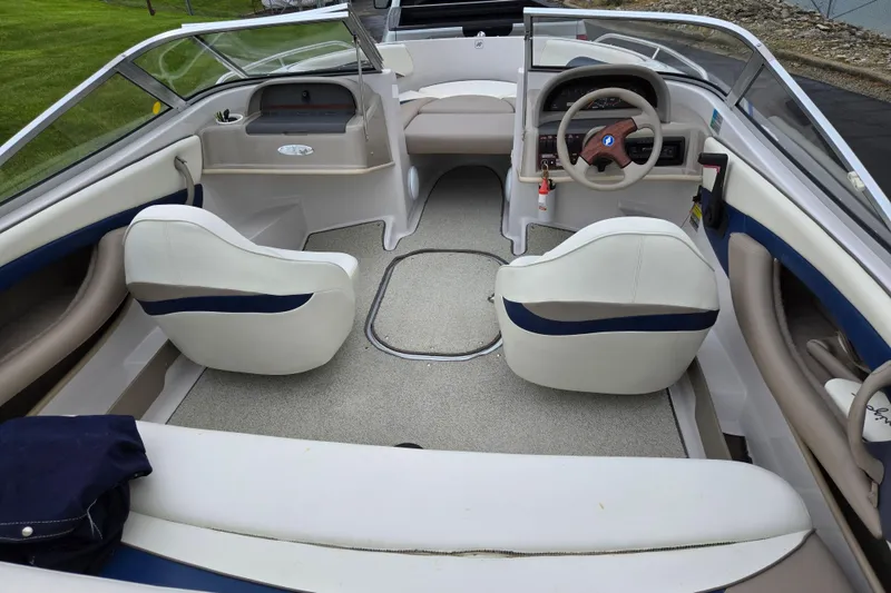 Slide: The Image of 1998 Four Winns 180 Horizon boat interior with white seating and steering wheel. - 10