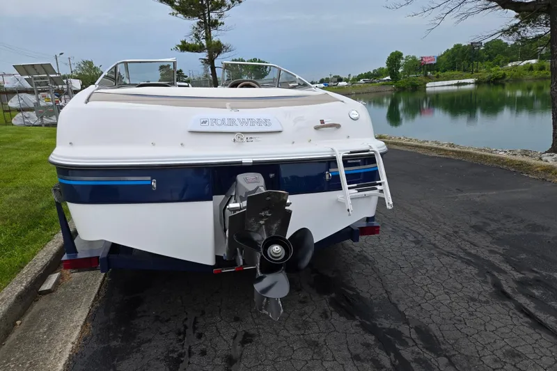 Slide: The Image of 1998 Four Winns 180 Horizon boat parked near a serene lake. - 2