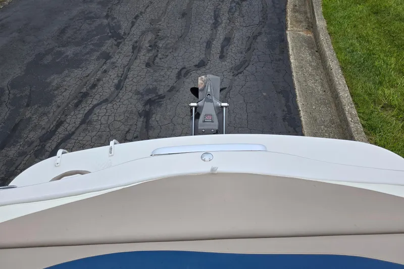 Slide: The Image of 1998 Four Winns 180 Horizon boat on a trailer, parked on a cracked asphalt road. - 23